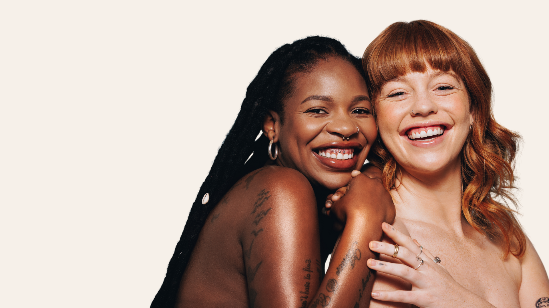 two women smilling in front of beige background