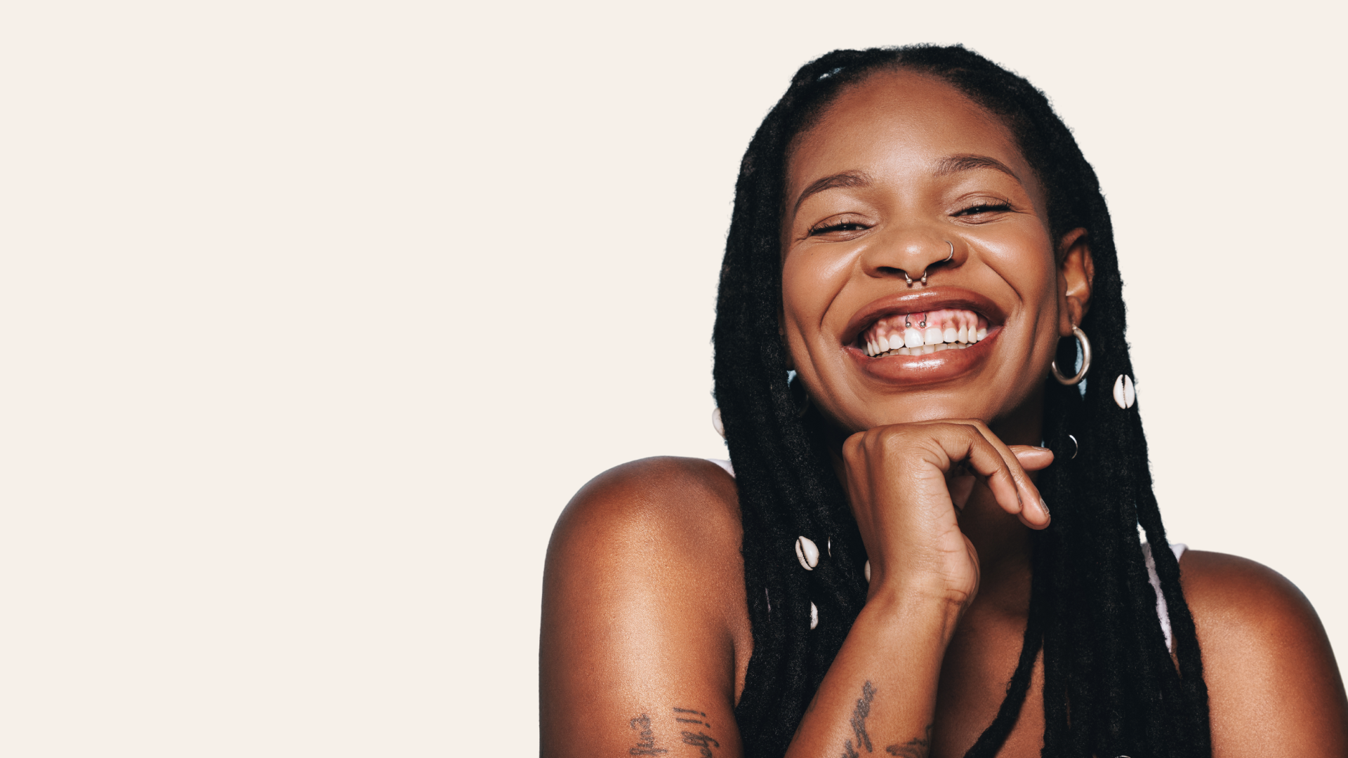 women smilling in front of beige background