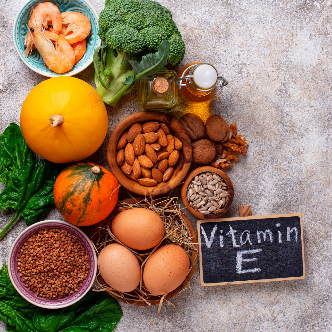 a small blackboard with "Vitamin E" written on, prawns, broccoli, pumpkin, walnut, almond, egg, spinach