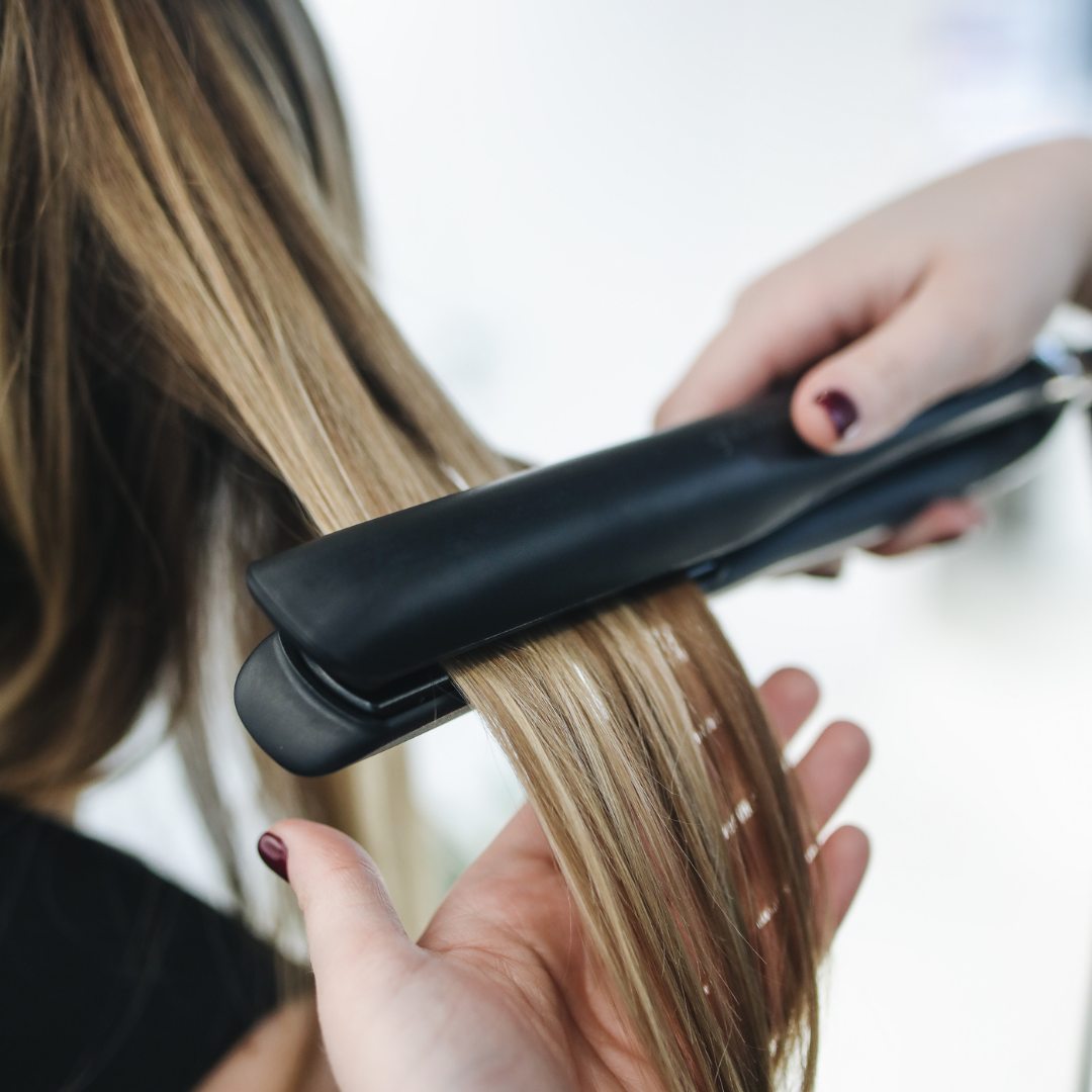 Person Ironing a Woman's Hair
