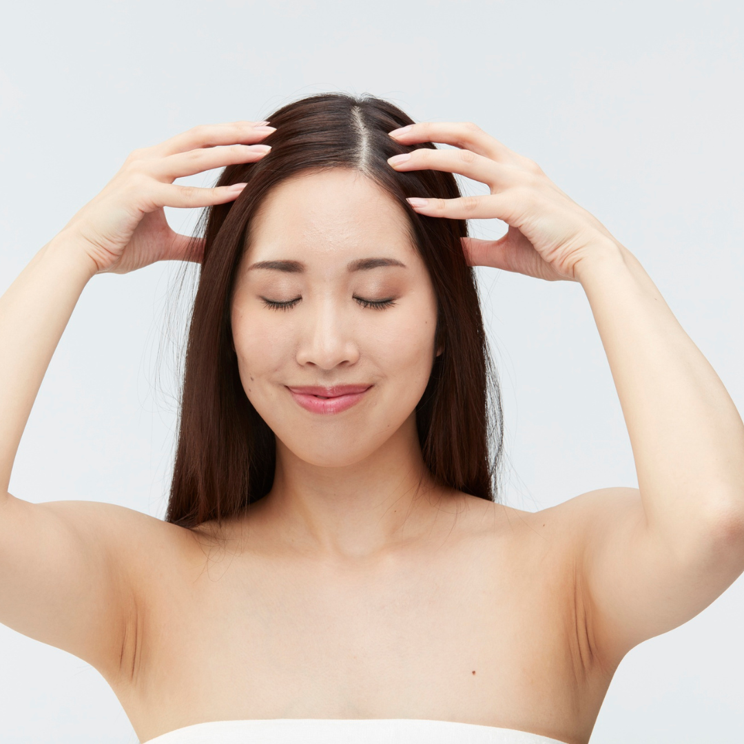 woman massages her hair scalp