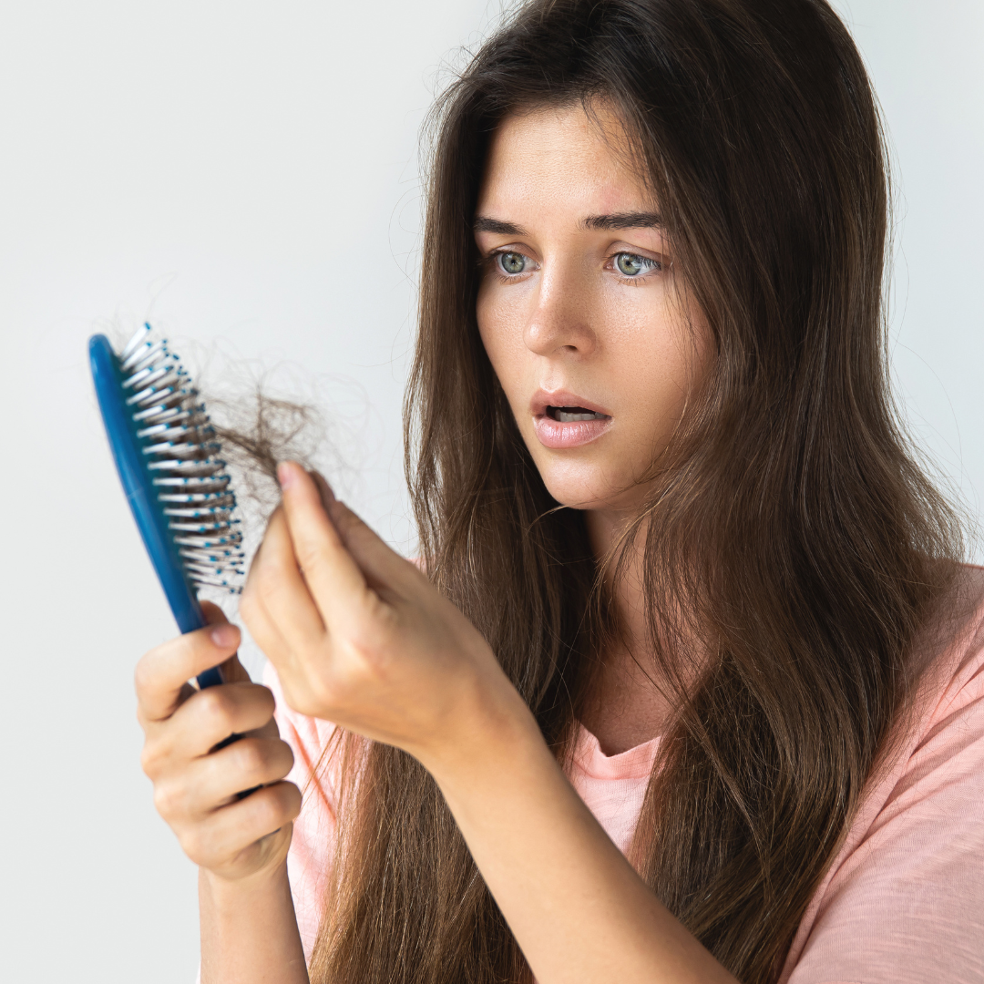 woman shock looking at the bunch of hair on her comb