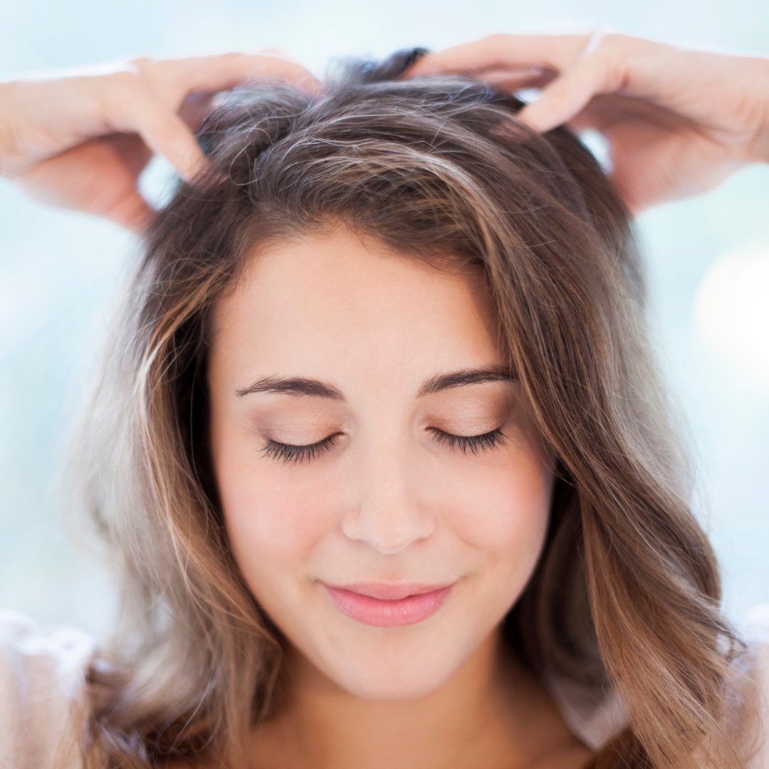 woman giving herself a scalp massage
