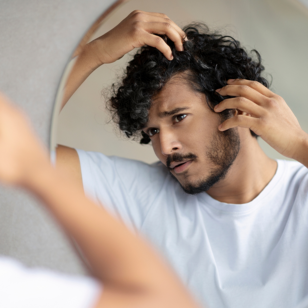 man checking at his hair through mirror