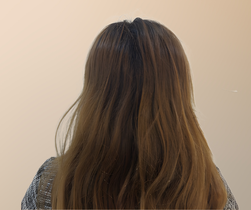 Back view of a person with long, wavy hair on a beige background